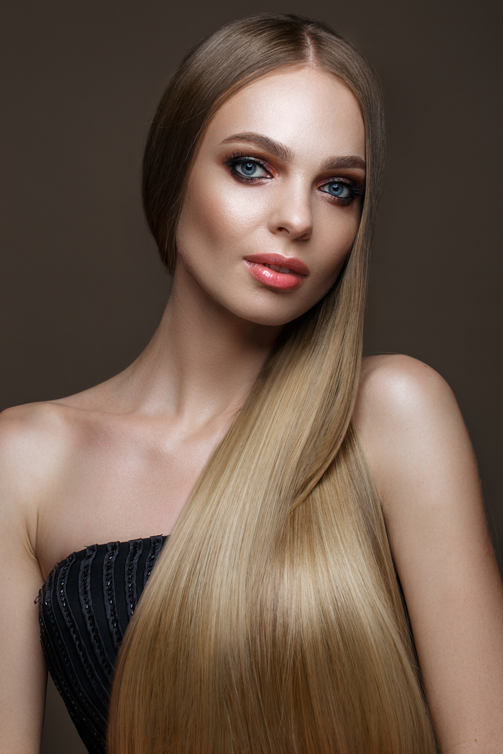 Beautiful blond girl with a perfectly smooth hair, classic make-up. Beauty face